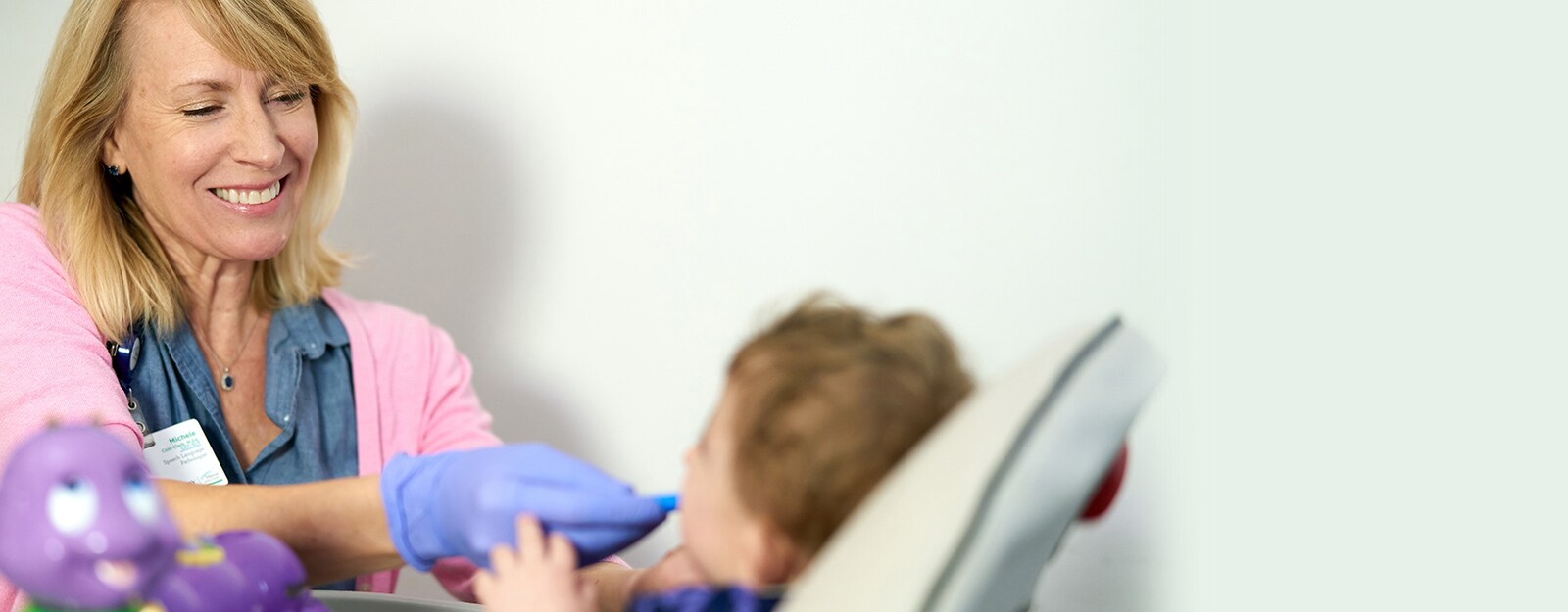 little girl being fed in highchair at marcus autism center