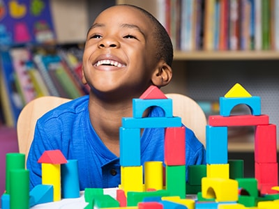 Curtis laughing playing with blocks at marcus autism center